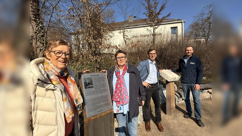 Eine neue Tafel informiert zukünftig auf Deutsch und Englisch über den in Warburg aufgewachsenen jüdischen Verleger Emil Herz. Die Initiatorinnen der Stolperstein-Gruppe Irmgard Heuel (v.l.) und Ruth Kröger-Bierhoff sowie Bürgermeister Tobias Scherf und Touristiker Lucas Lambracht freuen sich, dass der 2024 neu gestaltete Emil-Herz-Platz nun einen textlichen Bezug zu seinem Namensgeber hat. (Foto: Stadt Warburg)