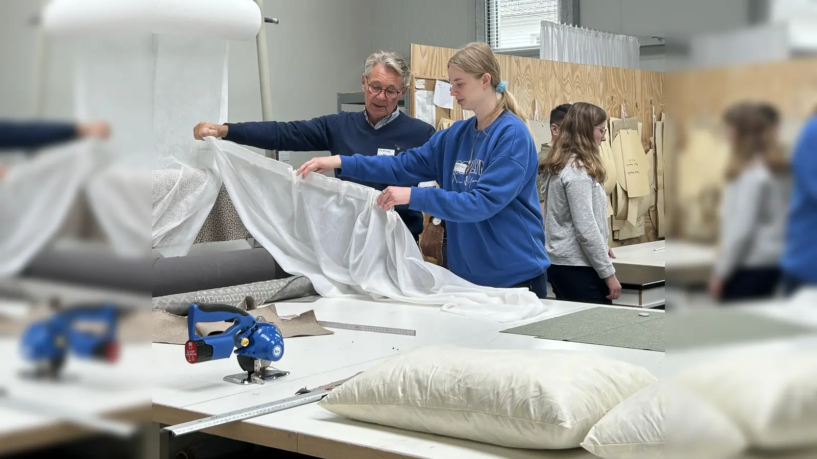 „Tag der offenen Betriebstür“: Hier bei der Sapo Sattlerei und Polsterei in Höxter. Mitarbeiter Michael Köster präsentiert selbst erstellte Gardinen. (Foto: Kreishandwerkerschaft Höxter-Warburg)
