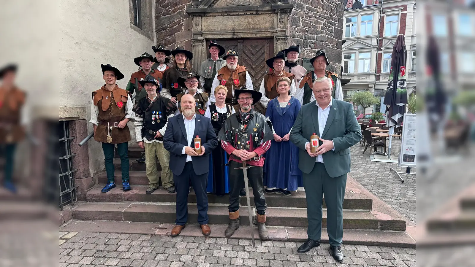 Die Historischen Schützen in ihren traditionellen Uniformen und Gewändern beim Auftakt des Marsches im Historischen Rathaus Höxter. Vorne v.l.: Marsbergs Bürgermeister Matthias Koch, Michael Jucke nath und Bürgermeister Daniel Hartmann. (Foto: Stadt Höxter)