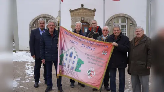 Bürgermeister Hermann Temme und Dirk Brassel von der Stadt nahmen die Vereinsfahne vom ehemaligen Vorstand des MGV für das Stadt-Archiv entgegen. (Foto: privat)