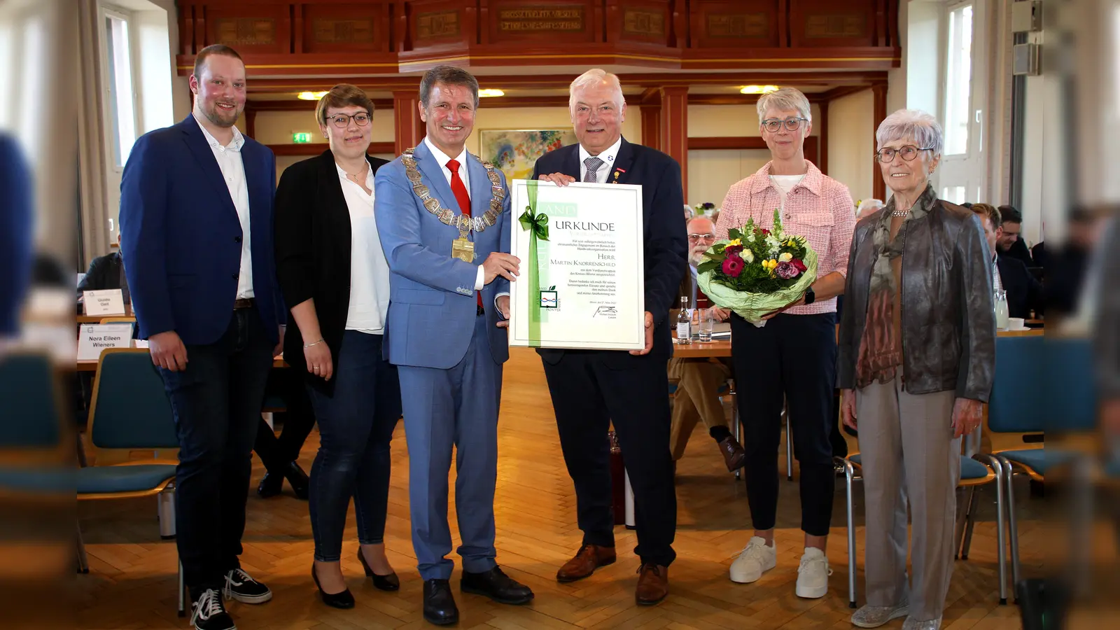 Martin Knorrenschild erhält von Landrat Michael Stickeln für seine Verdienste neben der Auszeichnung mit dem Verdienstwappen auch eine Urkunde des Kreises Höxter. Auf dem Foto (v.l.), Sohn Maurice, Tochter Soraya, Landrat Michael Stickeln, Martin Knorrenschild, Ehefrau Monika Knorrenschild und Schwiegermutter Margret Bade. (Foto: Kreis Höxter)