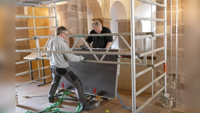 Mit größter Sorgfalt bereiten Restaurator Matthias Rüenauver (rechts) und sein Mitarbeiter Olav Renger im Johanneschor den Hub der berühmten Inschriftentafel vor. (Foto: Kirchengemeinde Corvey)