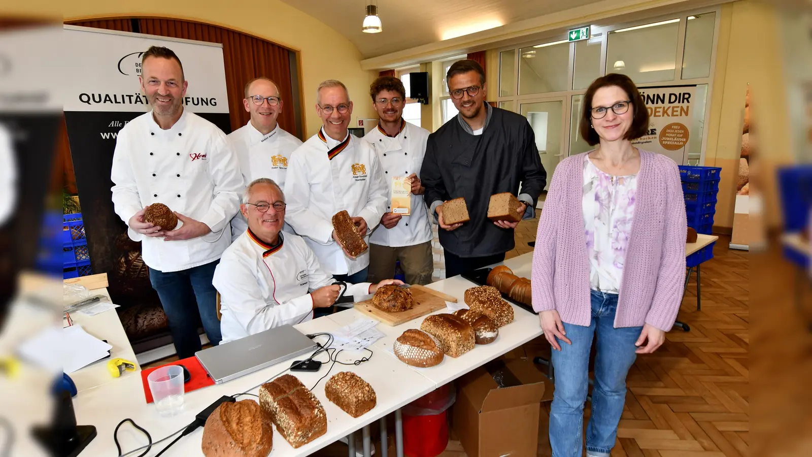 Der Vorstand der Bäcker-Innung Höxter-Innung: Brotprüfer Michael Isensee (sitzend) mit Daniel Henke (Bäckerei Henke), André Bielemeier (Bäckerei Bielemeier), Ansgar Krawinkel (Bäckerei Engel), Felix Engel (Bäckerei Engel), Benedikt Goeken („Goeken backen“) sowie die Konrektorin Simone Meyer der „Schule unter der Iburg“. (Foto: Kreishandwerkerschaft Höxter-Warburg)