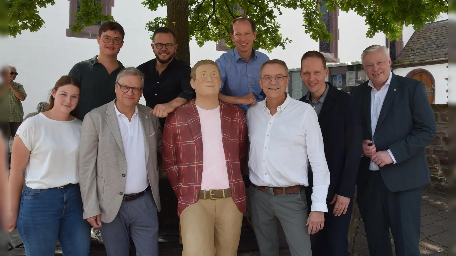 Einer der neuen Alltagsmenschen wird ganz persönlich willkommen geheißen, während er weiter den Blick auf die Dechanei genießt (hinten v.l.): Maik Marquard (Maprom), Sebastian Bensch (Ölmühle Solling), Mark Becker (Gebrüder Becker), (vorn v.l.) Madita Alberding (Geschäftsführerin Huxarium Gartenpark), Frank Sievers (Hotel Niedersachsen), Elmar Düker (Firma Knop), Jens Klingemann (Modehaus Klingemann) und Bürgermeister Daniel Hartmann. (Foto: Marc Otto)