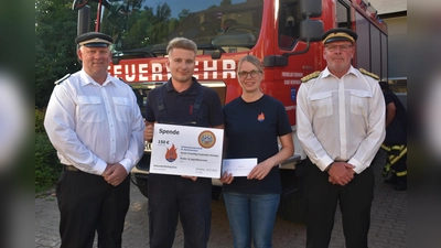 Schützenkönig Heinz Jürgen Schüttemeyer und Oberst Matthias Alberding übergaben eine Spende an den Kinderfeuerwehrwart Lukas Peters und die Jugendfeuerwehrwartin Annette Knipping.  (Foto: Barbara Siebrecht)