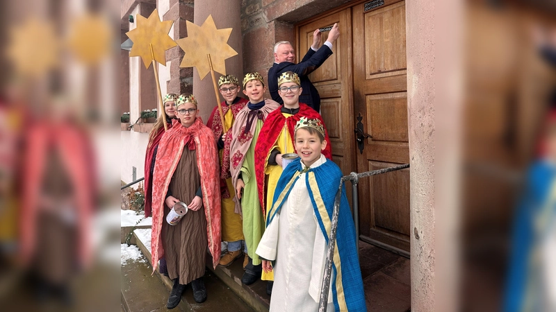 Bürgermeister Hartmann freut sich über den Besuch der Sternsinger; v.l. Marlene, Henri, Philipp, Justus, Benjamin und Theo. Der erste Segensaufkleber wurde an der Tür des Stadthauses angebracht. (Foto: Stadt Höxter)