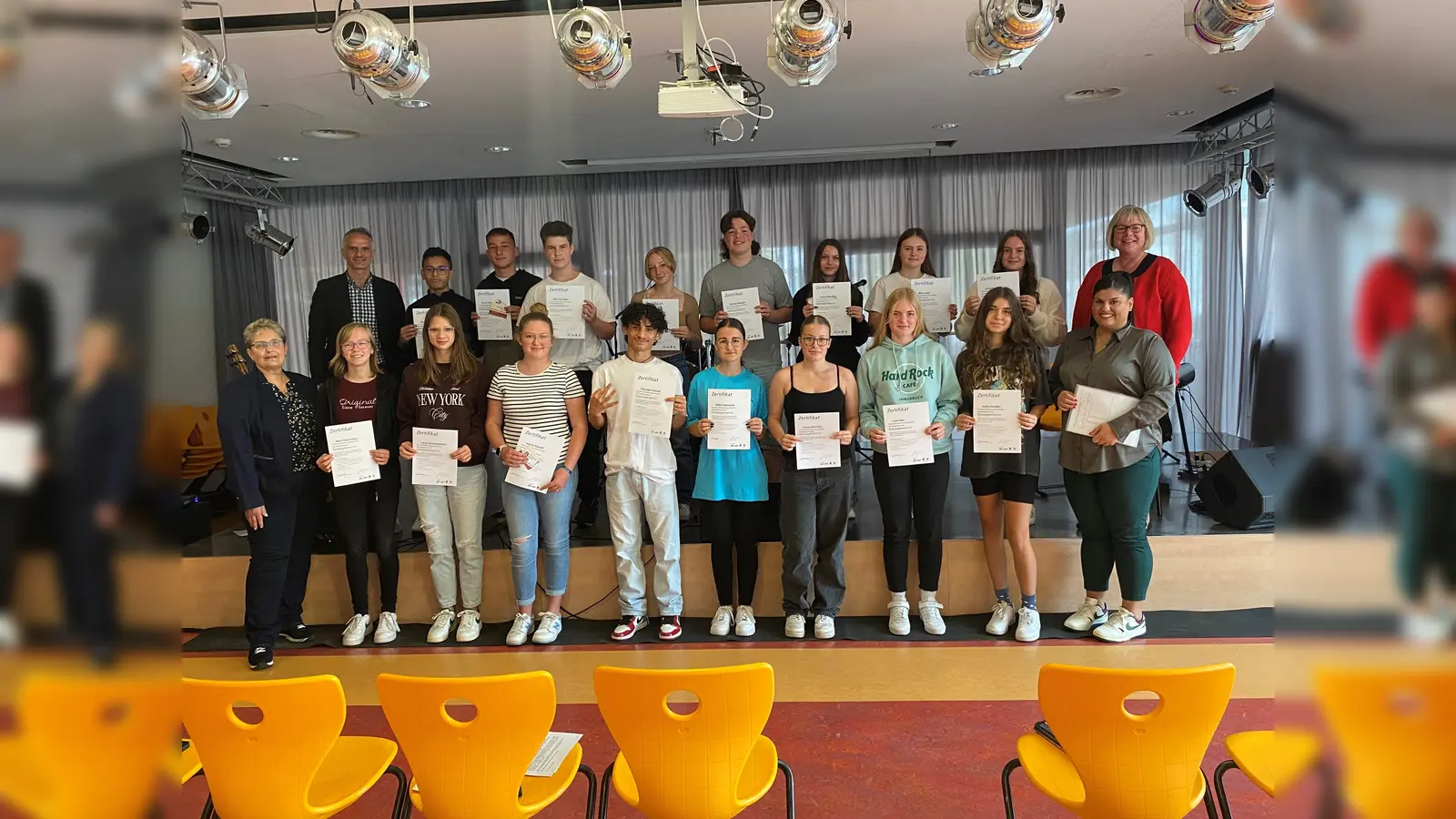 Die Schülerinnen und Schüler sind sichtlich stolz auf ihre Zertifikate als Fahrzeugbegleiterinnen und -begleiter: (hinten von links) Schulleiter Driton Mazrekaj, Aayan Malik, Kevin Kollmeyer, Maurice Kelm, Stacey Gabler, Simeon Bergau, Lena Alberding, Mia Lange, Lenja Koch, Erste Kreisbeigeordnete Silke Engler; (vorne von links) Ausbilderin Birgit Schaumburg, Mila Patermann, Lenja Schüttemeyer, Hanne Rudolff, Faizullah Gulzari, Sofia Gobrecht, Anna Schröder, Leni Otto, Anika Schäfer und Trainerin Gentiana Syla.  (Foto: Landkreis Kassel)