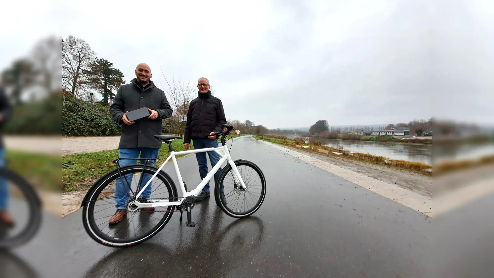 Auf dem wieder geöffneten Weserradweg: LGS-Geschäftsführer Jan Sommer (links) überreicht das moderne E-Bike an Gewinner Michael Schulte. (Foto: LGS Höxter/Madita Schellenberg)
