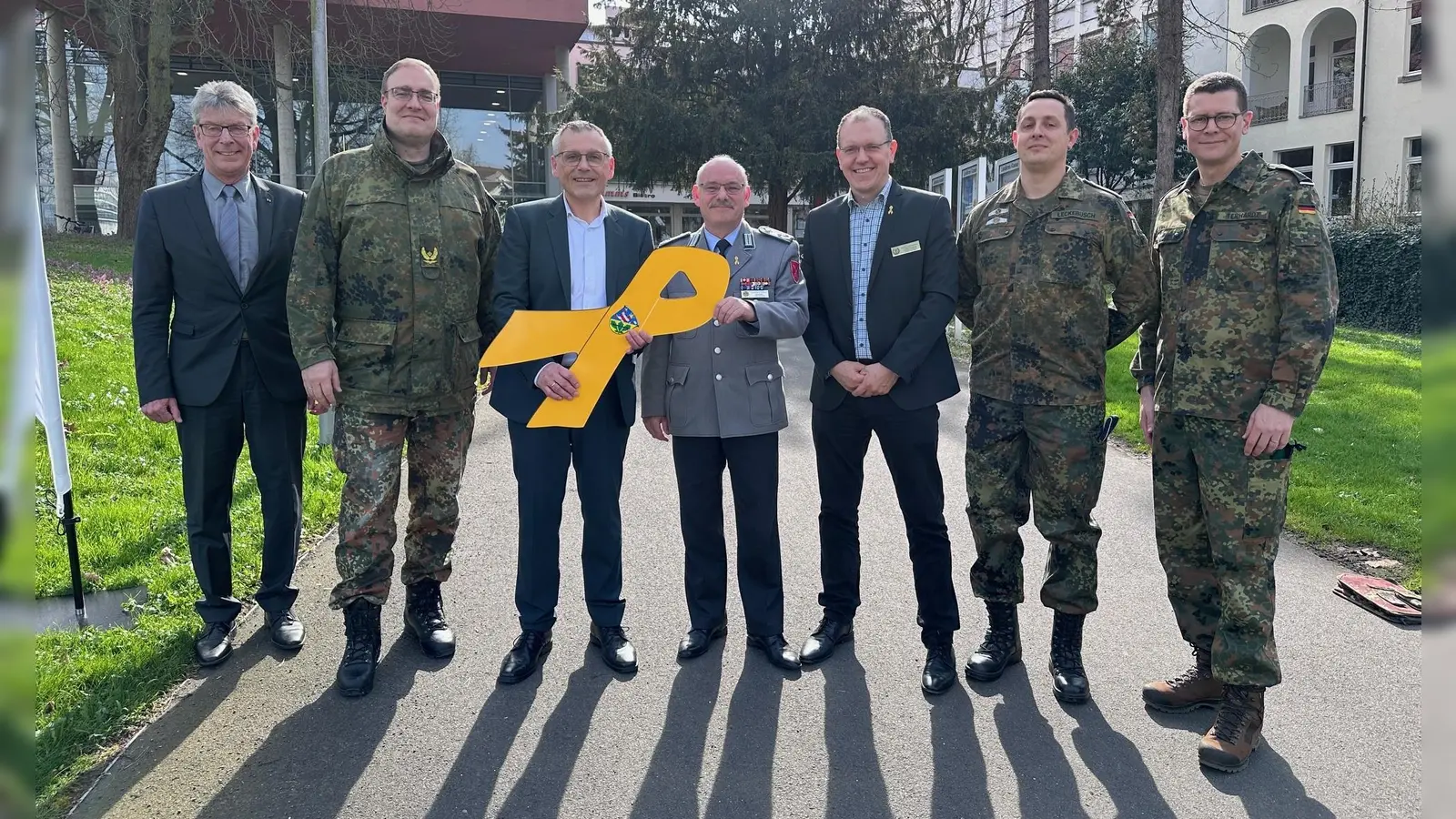 Verleihung der „Gelben Schleife” durch den Brigadegeneral Bernd Stöckmann (2.v.l.) und Oberstleutnant Lutz Meier (in der Mitte) an Landrat Andreas Siebert (3.v.l.). Ebenfalls auf dem Bild: Kreistagspräsident Andreas Güttler (1.v.l.) sowie Carsten Pfenning vom Deutschen Bundeswehrverband (4.v.l.), Major Michael Leckebusch vom Kreisverbindungskommando sowie Oberstleutnant Tobias Terhardt, Leiter des Heeresmusikkorps Kassel. (Foto: Landkreis Kassel)