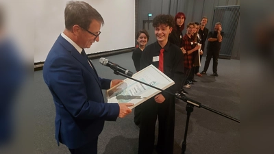 Neil Kahrmann, der die Rolle des „Benvolio“ spielte, freute sich über die Urkunde aus den Händen von Landrat Michael Stickeln. (Foto: Kreis Höxter)