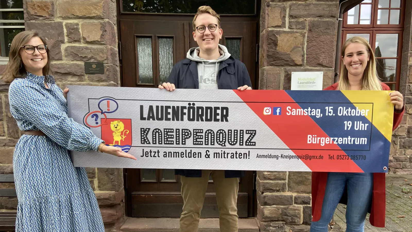 Präsentieren das Banner zum ersten Lauenförder Kneipenquiz: (v.r.) Sophia Reinken, Moderator Stefan Schade und Raphaela Willwerth. (Foto: Gerold Reinken)