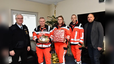 Landrat Michael Schünemann und der Vorsitzende des Kreisfeuerwehrverbandes, Ralf Knocke, zusammen mit den Rettungsdienstlern der Rettungswache Bodenwerder. (Foto: Peter Drews/Landkreis Holzminden)