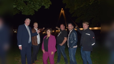 Höxters Weserbrücke in neuem Licht – v.l. Bürgermeister Daniel Hartmann, Jan Hanebaum (Fa. Elektro Beckhoff), Baudezernentin Claudia Koch und Michael Schafstall (Stadt Höxter), sowie Christian Schnell und Marcel Grawe von der Firma Elektro Beckhoff bei der Premiere. (Foto: Stadt Höxter)