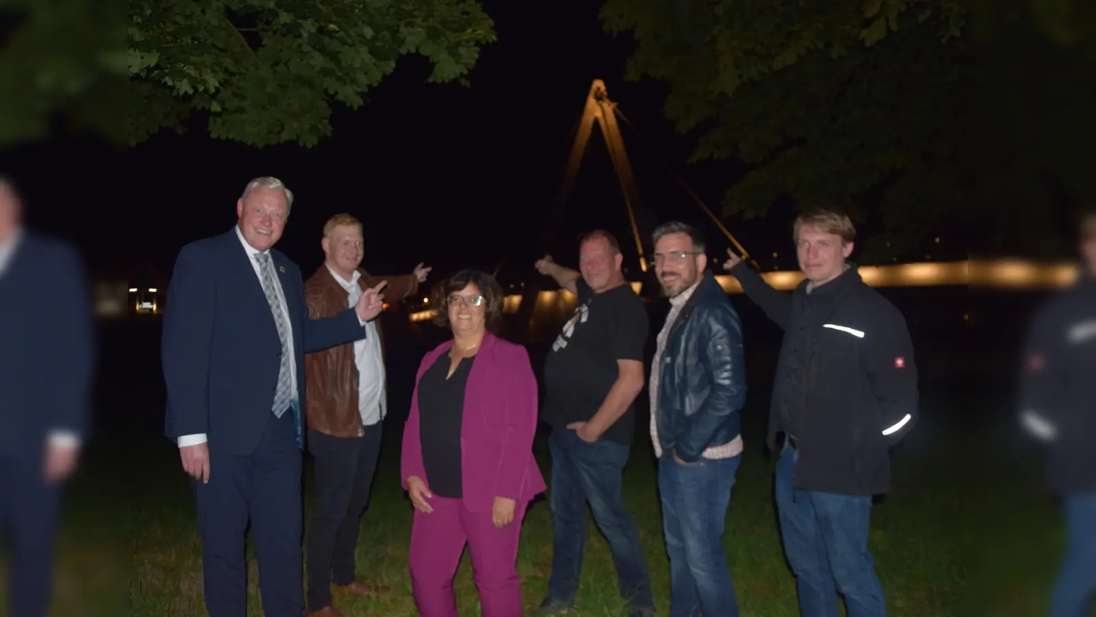 Höxters Weserbrücke in neuem Licht – v.l. Bürgermeister Daniel Hartmann, Jan Hanebaum (Fa. Elektro Beckhoff), Baudezernentin Claudia Koch und Michael Schafstall (Stadt Höxter), sowie Christian Schnell und Marcel Grawe von der Firma Elektro Beckhoff bei der Premiere. (Foto: Stadt Höxter)