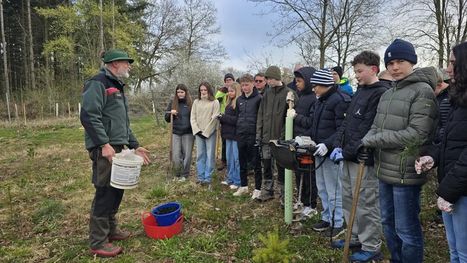 Was wird gepflanzt: Revierförster Stephan Klotz erklärt den Jugendlichen Wissenswertes über Baumhasel und Schwarznuss. (Foto: Hansestadt Warburg)