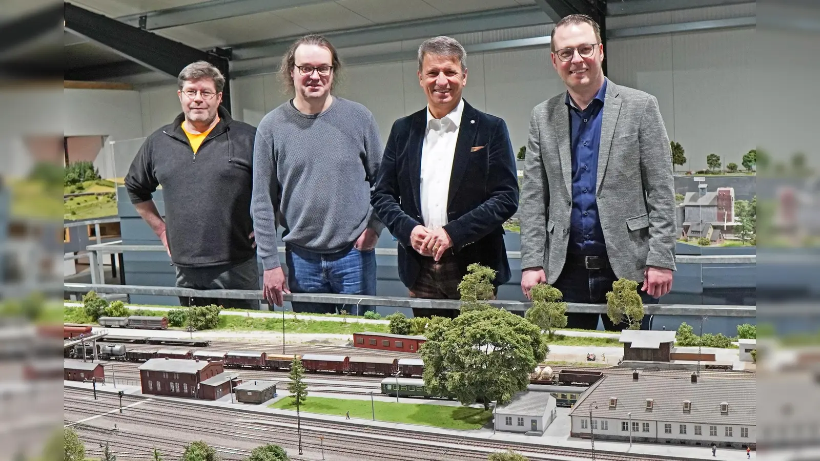 Setzen sich gemeinsam für eine Unterstützung der Modellbundesbahn ein, um deren Fortbestand für die Zukunft zu sichern (v.l.): die Modellbauer Norbert Sickmann und Karl Fischer, Landrat Michael Stickeln und Brakels Bürgermeister Alexander Kleinschmidt. (Foto: Stadt Brakel)