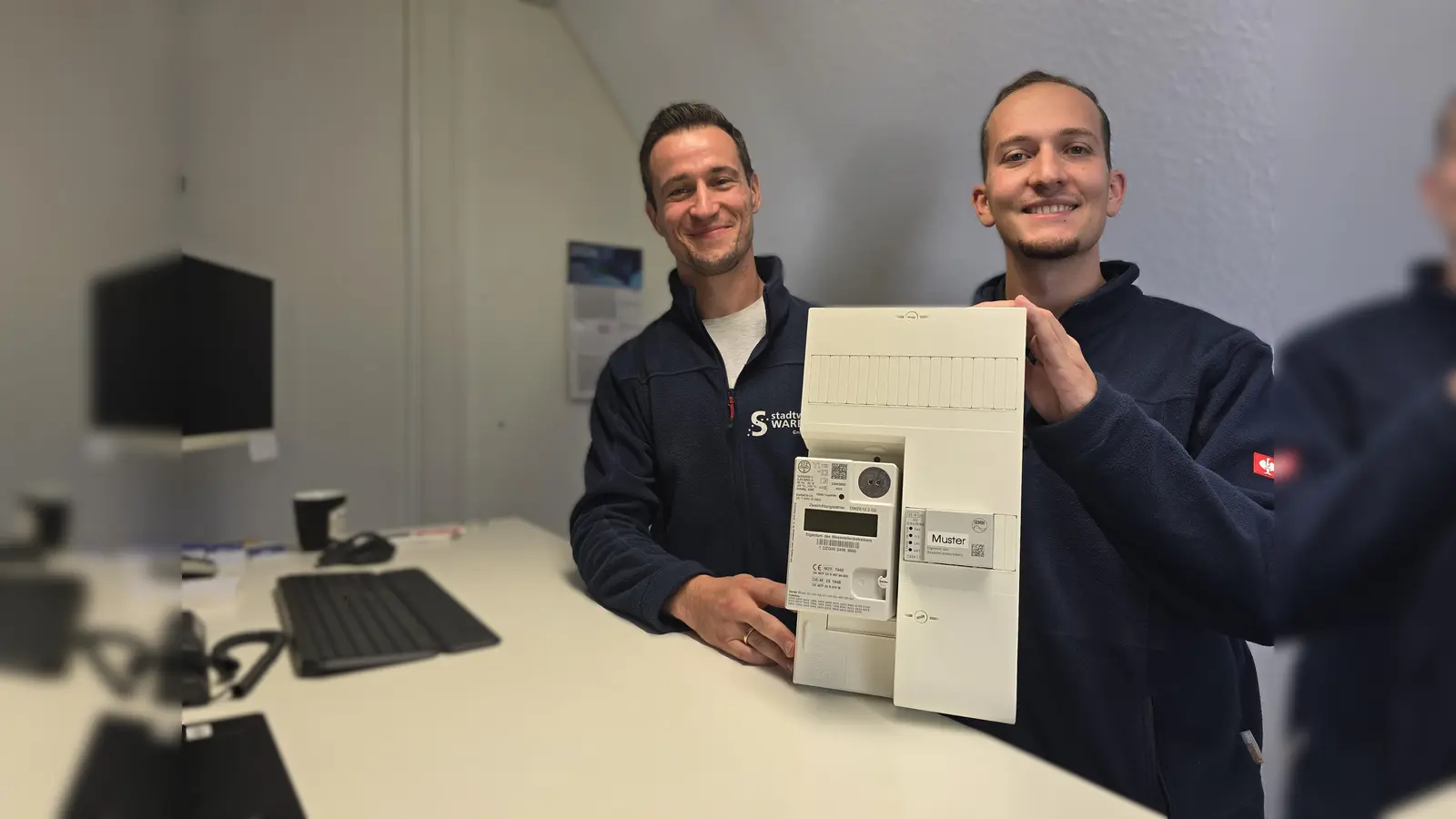 Was ist ein Smart-Meter und welche Vorteile bietet er: Kevin Neifer (links) und Besijan Neziri beraten und informieren in der Gewerbeausstellung am Stand der Stadtwerke Warburg GmbH über den intelligenten Stromzähler. (Foto: Stadtwerke Warburg)