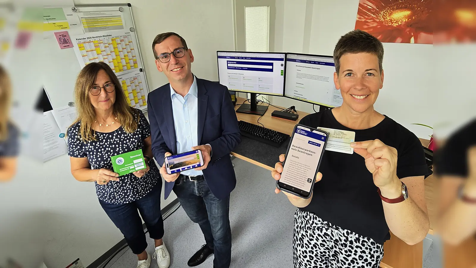 In der Verwaltung wird gemeinsam am weiteren Ausbau eines flexiblen, nutzerfreundlichen Angebots gearbeitet: Susanne Koch (links: Ansprechpartnerin Anwohnerparken), Bürgermeister Tobias Scherf und Birgit Hoppe (Digitalisierungsbeauftragte) stellen die neuen digitalen Leistungen vor, die auch in Verbindung mit dem Online-Ausweis und dem Smartphone genutzt werden können. (Foto: Stadt Warburg)