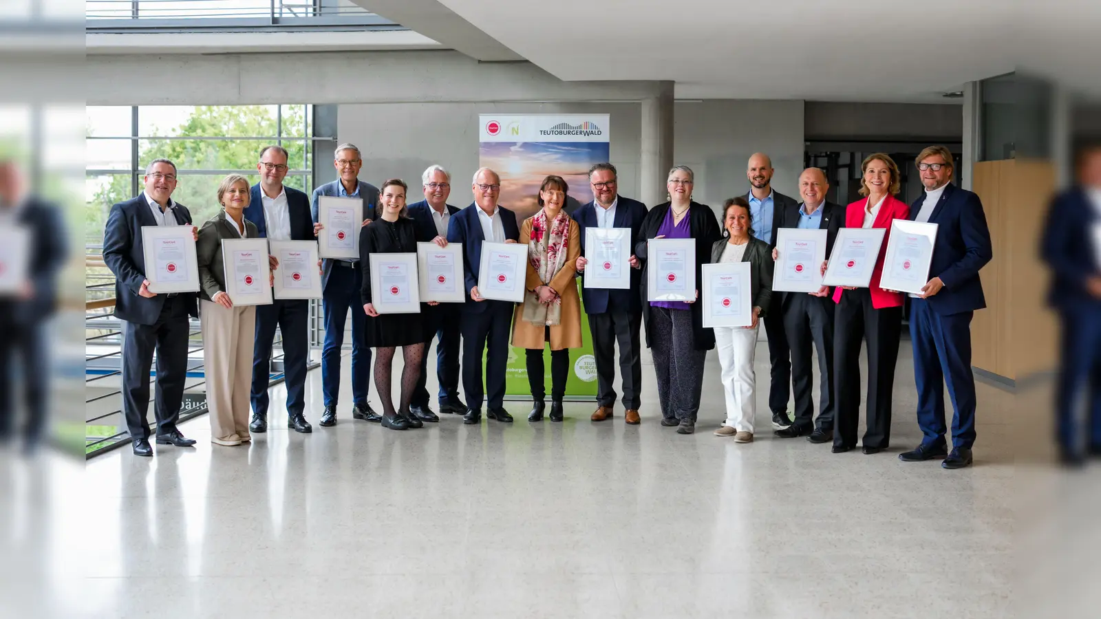 Freuen sich über die Zertifizierung der Urlaubsregion Teutoburger Wald/OWL als „Nachhaltiges Reiseziel“: Landrat Dr. Axel Lehmann (Kreis Lippe), Nikola Weber (pro Wirtschaft GT GmbH), Martin Knabenreich (Bielefeld Marketing), Landrat Sven-Georg Adenauer (Kreis Gütersloh), Maria Hecker (Interkommunale Wirtschaftsförderungsgesellschaft mbH im Kreis Herford), Landrat Jürgen Müller (Kreis Herford), Oberbürgermeister Pit Clausen (Stadt Bielefeld), Regierungsvizepräsidentin Anke Recklies (Bezirksregierung Detmold), Björn Böker (OstWestfalenLippe GmbH), Nicole Streitz (Kreis Minden-Lübbecke), Angela Giraldo (TourCert), Markus Backes (OstWestfalenLippe GmbH), Landrat Christoph Rüther (Kreis Paderborn), Edith Rehmann-Decker (Kreis Paderborn) und Günter Weigel. (Foto: Lippe Tourismus & Marketing GmbH / privat)
