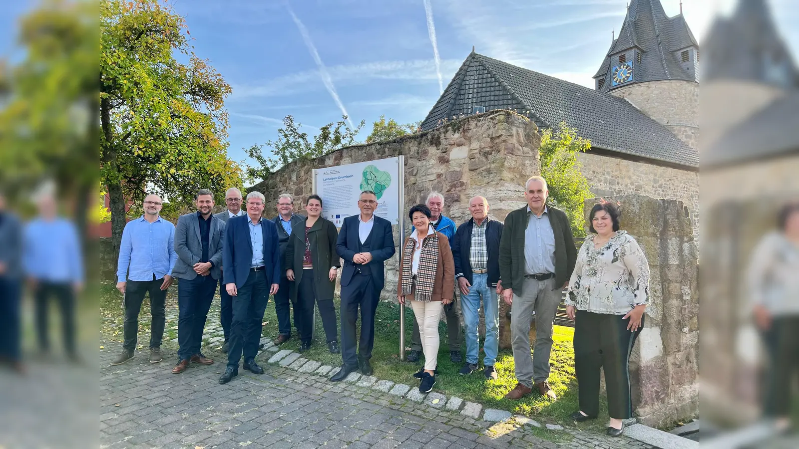 An der Kirche Crumbach in Lohfelden gibt es jetzt einen von 15 Audiowalks: (v.l.) Rafael Jové, Geschäftsführer FunkHaus Ost, Andreas Schönemann, Sprecher der TAG GrimmSteig-ErlebnisRegion, Bürgermeister Uwe Jäger, Peter Nissen, Leiter Servicezentrum Regionalentwicklung, Stefan Frankfurth, Vorsitzender Tag Habichtswald, Manuela Greipel, Geschäftsführerin Naturpark Reinhardswald, Landrat Andreas Siebert, Bärbel Fehr, Erste Beigeordnete der Gemeinde Lohfelden, die Sprecher Volker Wagner, Gerhard Fehr und Herbert Brethauer sowie Pfarrerin Andrea Fugmann-Szugfill.  (Foto: Landkreis Kassel)