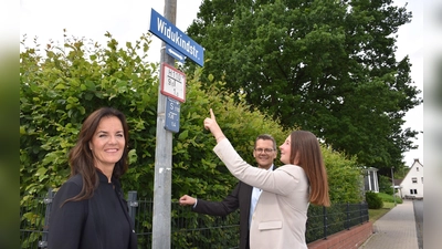 INa Kreimer, Micahel Meier und Madita Alberding mit dem Schild der Widukindstraße.  (Foto: Huxarium Gartenpark)