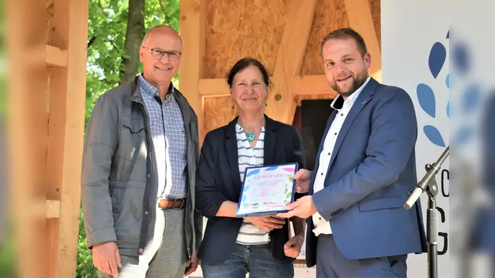 Die Urkunde für den 1. Preis beim Kunstwettbewerb übergaben Thomas Schöning (Vorsitzender des Fördervereins der Landesgartenschau Höxter) und Pfarrer Tim Wendorff (interreligiöses Projektteam Schöpfungsgarten) bei der feierlichen Enthüllung der Skulptur vor dem Schöpfungsgarten.  (Foto: Barbara Siebrecht)