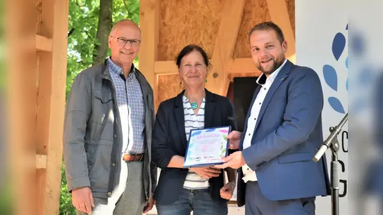 Die Urkunde für den 1. Preis beim Kunstwettbewerb übergaben Thomas Schöning (Vorsitzender des Fördervereins der Landesgartenschau Höxter) und Pfarrer Tim Wendorff (interreligiöses Projektteam Schöpfungsgarten) bei der feierlichen Enthüllung der Skulptur vor dem Schöpfungsgarten.  (Foto: Barbara Siebrecht)