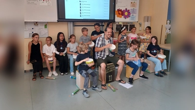 Julian Schmitz mit jungen Musikerinnen und Musikern der Schule am Nicolaitor – stolz präsentieren sie ihre selbstgebauten Blumentopftrommeln aus dem Projekt „Experimenteller Instrumentenbau“. (Foto: Stadt Höxter)