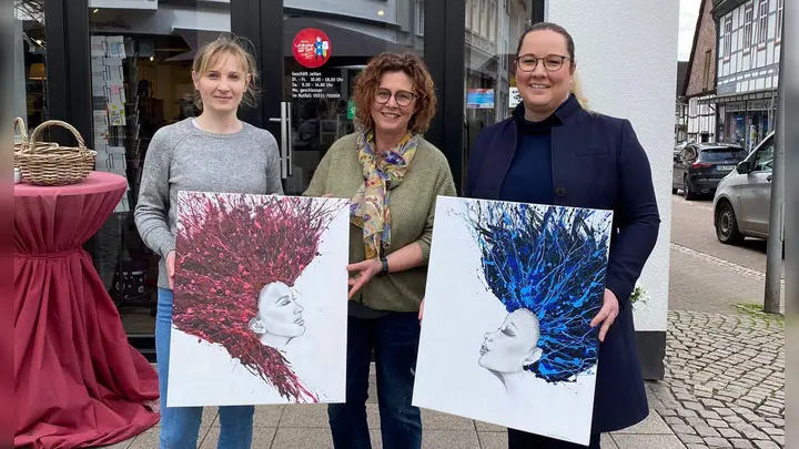 Lina Künnecke (l.) und Miriam Bullmann (r.) vom Ladies‘ Circle übergeben zwei der vier Auktionsbilder an Evelyn Kappey, die die Bilder im „WeinKap“ in Holzminden ausstellt. (Foto: Ladies Circle )