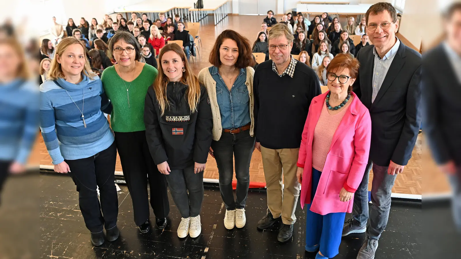 Das Foto aus der Aula der Brede zeigt (v.l.) Christiane Seehase (Verantwortliche für den Austausch an der Brede), die französischen Lehrerinnen Christèle Bodet, Hélène Praud, Élodie Picot, Martin Blumenthal (ehemaliger Verantwortlicher für den Austausch), die stellvertretende Bürgermeisterin Ursula Grewe sowie Dr. Matthias Koch mit den Teilnehmerinnen und Teilnehmern aus Frankreich und Deutschland im Hintergrund. (Foto: privat)