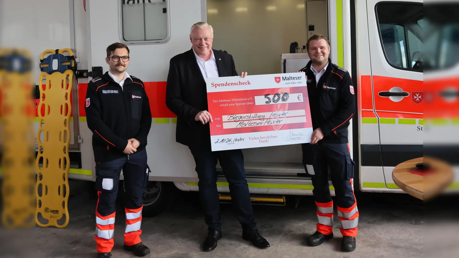 Übergabe des symbolischen Spendenscheck für die neue Fahrtrage (v.l.): David Müller-Reich, Malteser Stadtbeauftragter, Bürgermeister Daniel Hartmann und Noah Finn Schikora, Malteser Geschäftsführer. (Foto: Malteser)