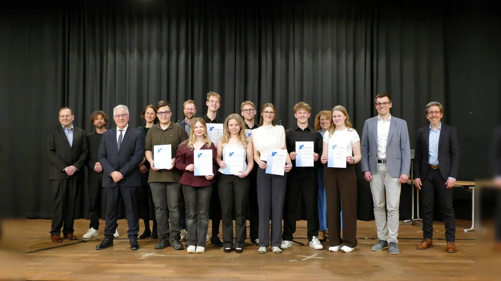 Alle Preisträgerinnen und Preisträger zusammen mit ihren Laudatorinnen und Laudatoren sowie Schulleiter Antonio Burgos und Sparkassen-Regionalleiter Thomas Groppe.<br>Vordere Reihe, von links nach rechts:<br>Schulleiter Antonio Burgos, Preisträger Luca Ramón Leiweke, Preisträgerin Anastasia Utigenow, Preisträgerin Elisa-Marie Kluwe, Preisträgerin Hannah Wittrock, Preisträger Raphael Schübeler, Preisträgerin Leonie Tenter, Sparkassen-Regionalleiter Thomas Groppe, Laudator Christoph Paetzold.<br>Hintere Reihe, von links nach rechts:<br>Laudator Frank Kieseheuer, Laudator David Feldpausch, Laudatorin Janina Rüther, Laudator Benedikt Speer, Preisträger Mika Döhre, Preisträger Carlsson Wandtke, Laudatorin Antje Kanbach-Gocke.  (Foto: privat)