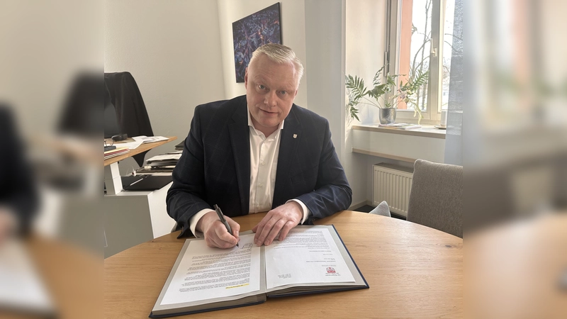 Bürgermeister Daniel Hartmann setzt seine Unterschrift unter den Widerspruch gegen den Ratsbeschluss zum Umbau des Postgebäudes „Uferstraße 2“. Mit seiner Unterschrift macht er deutlich: Die Zukunft des MVZ und des ehemaligen Postgebäudes soll auf fundierter fachlicher Grundlage entschieden werden. (Foto: Stadt Höxter)