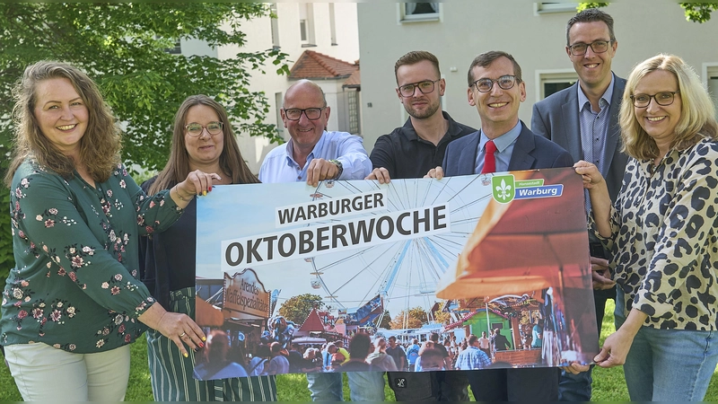 Kristina Imhoff (links) und Melanie Glade (rechts) organisieren die Warburger Oktoberwoche und freuen sich gemeinsam mit Festwirt Markus Köster und seinem Sohn Silas Köster (3. und 4. von links), Jessica Hartmann (2. von links, Marketing Mineralquellen Germete), dem ersten Beigeordneten Andreas Niggemeyer (2. von rechts) und Bürgermeister Tobias Scherf (3. von rechts) auf eine neu gestaltete, 77. Warburger Oktoberwoche mit einem „Extra-Festtag“. (Foto: Stefan Bönning)