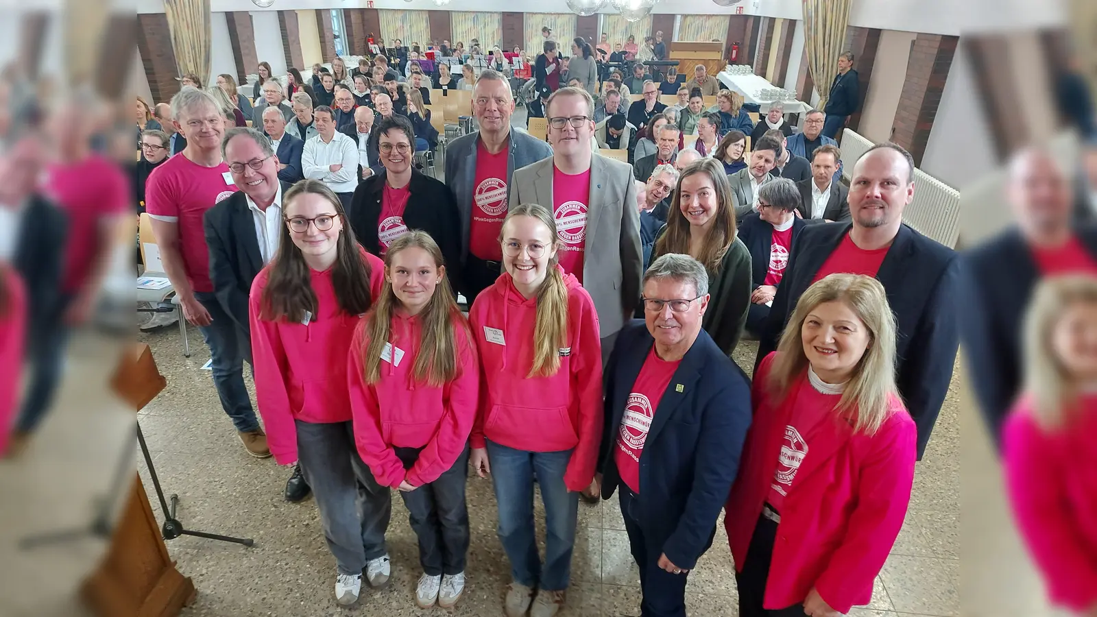 Auftaktveranstaltung Internationale Wochen gegen Rassismus und Rechtsextremismus im Kreis Höxter mit (vordere Reihe von links): Greta Stein, Mia Fritsche, Annie Johlen (die Moderatorinnen und Schülerinnen der Jahrgangsstufe neun des Gymnasiums St. Kaspar), stellvertretender Landrat Werner Dürdoth, Filiz Elüstü (Teamleiterin Kommunales Integrationszentrum Kreis Höxter) sowie (hintere Reihe von links) Jörg Lange (Gymnasium St. Kaspar), Historiker Norbert Ellermann (Erinnerungs- und Gedenkstätte Wewelsburg 1933 bis 1945), Schulleiterin Christin Johlen, IWgR-Botschafter und Landtagsabgeordneter Matthias Goeken, Bad Driburgs Bürgermeister Oliver Tölle, Marleen Menne (Vereinigte Volksbank eG) und Dominic Gehle (Abteilungsleiter Bildung und Integration beim Kreis Höxter). (Foto: Kreis Höxter)