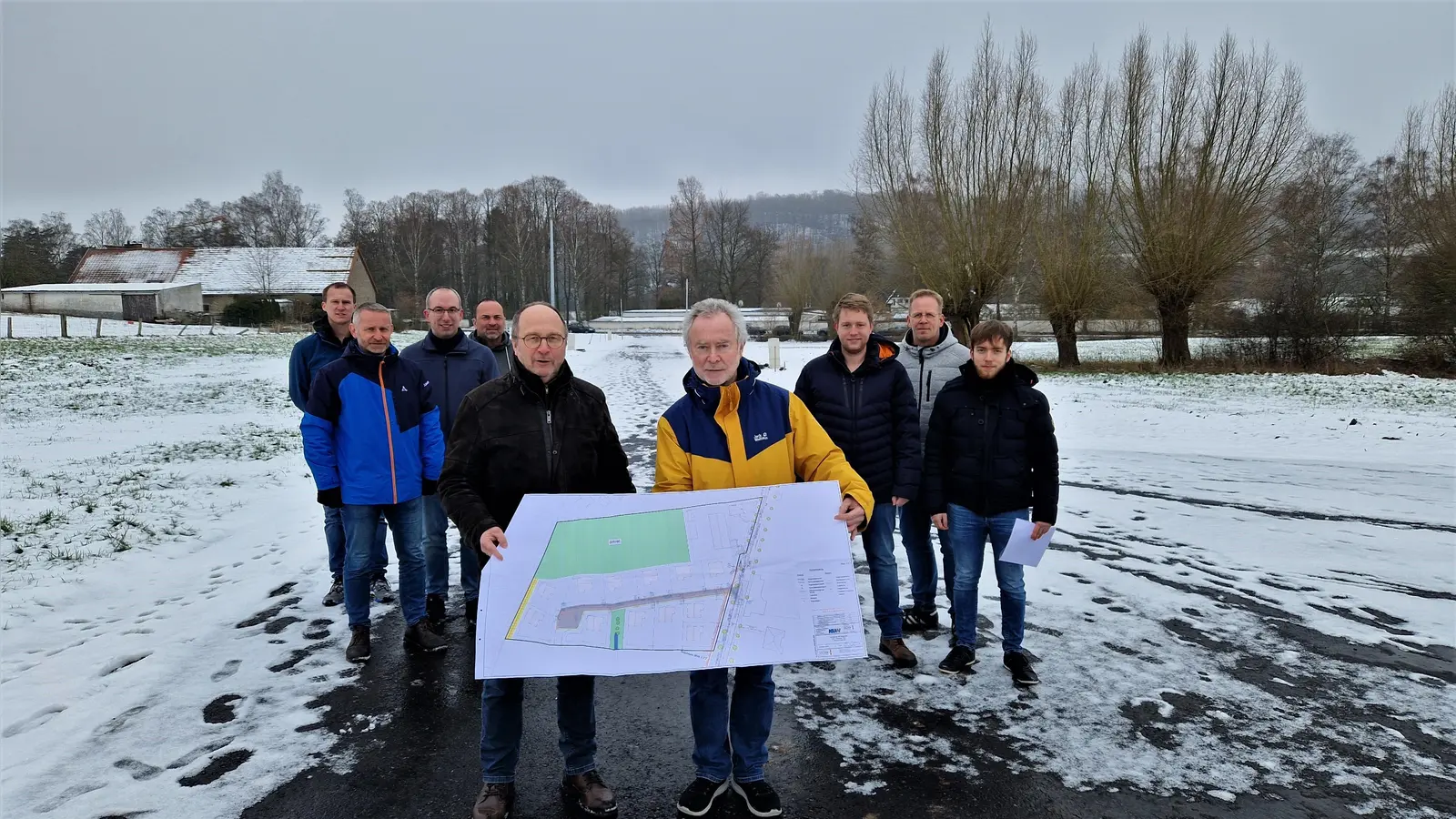 Helmut Schmitz (Stadtwerke Warburg) und Anton Volmer (Ingenieurbüro Volmer) mit der Karte des neu erschlossenen Baugebiets. Außerdem (v.l.): Peter Rehrmann (Firma Nolte Bau), Markus Engemann (Stadt Warburg, FB II – Bauen und Stadtentwicklung), David Ferber und Sebastian Maicher (beide Stadtwerke Warburg), Jonas Volmer (Ingenieurbüro Volmer), Stefan Rauscher (Firma Nolte Bau) und Konstantin Volmer (Ingenieurbüro Volmer). (Foto: Stadt Warburg)
