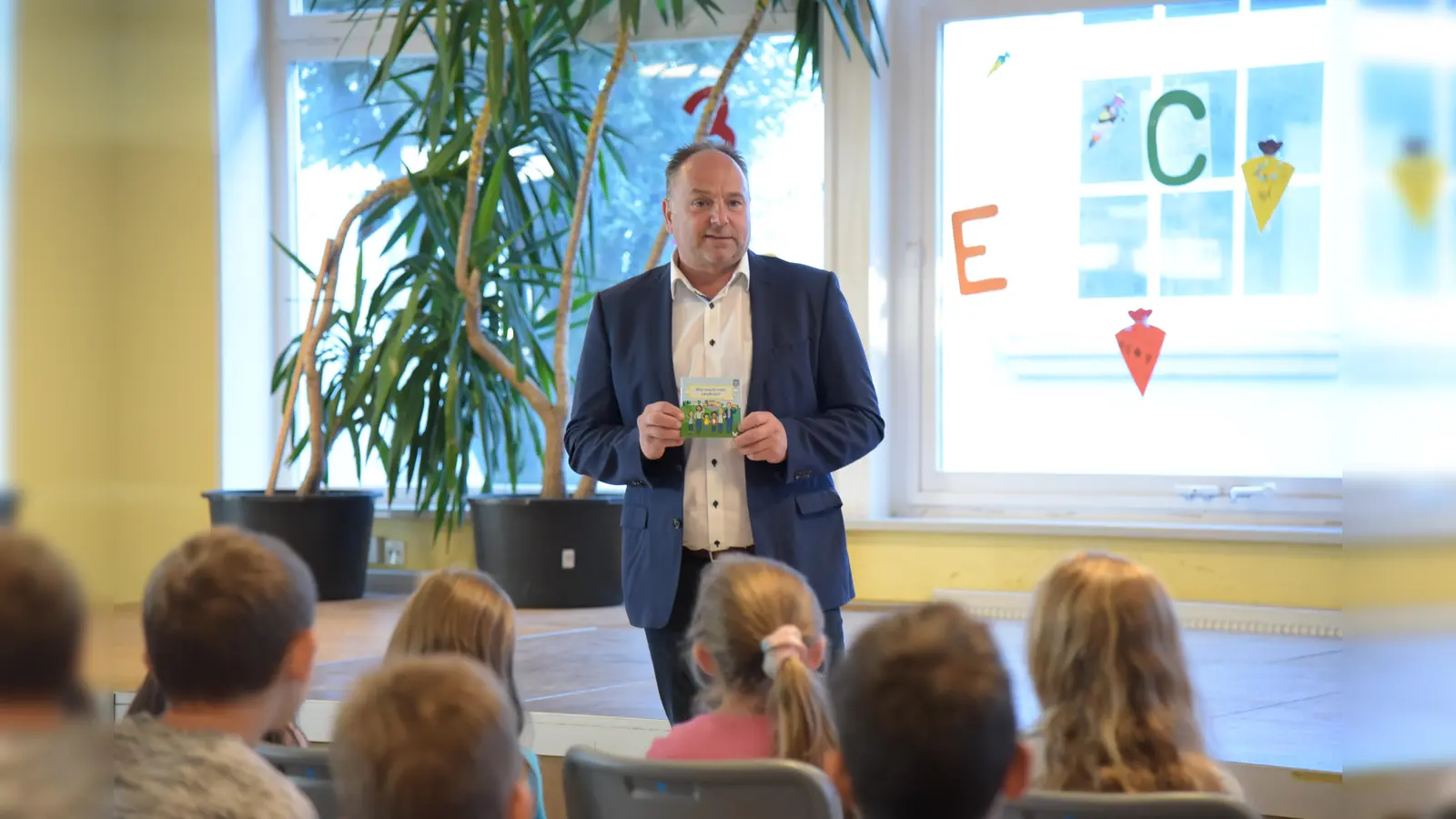 Landrat Michael Schünemann, hier bei der Verteilung der Pixibücher in der Schlossschule Bevern. (Foto: Peter Drews/Landkreis Holzminden)