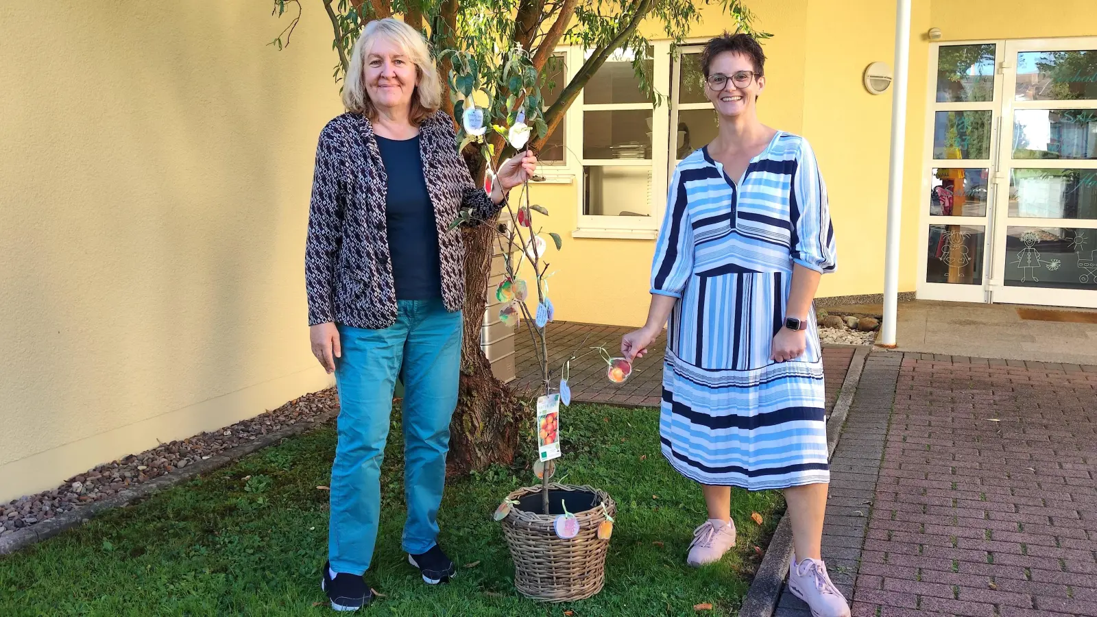 Heike Schäfers (links) freut sich gemeinsam mit Einrichtungsleiterin Stefanie Ernst über den Apfelbaum zum 35-jährigen Dienstjubiläum bei der AWO. (Foto: Doris Dietrich)