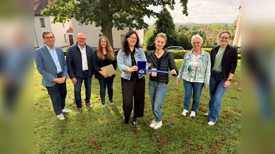 Bürgermeister Tobias Scherf (links) und Westenergie-Kommunalmanager Thorsten Hildebrandt (2. v. l.) freuten sich gemeinsam mit den Anwesenden über das herausragende Engagement der youngcaritas Warburg. (Foto: Stadt Warburg)