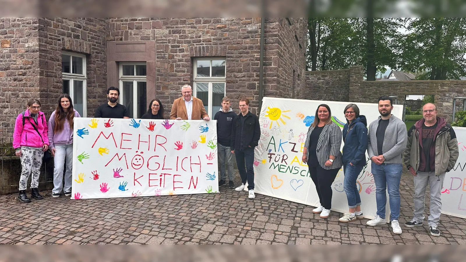 Gemeinsam mit Bürgermeister Daniel Hartmann präsentierten die Beteiligten die kreativen und eindringlichen Botschaften des Aktionstags. Von rechts: Evelyn Steinmeier, Madita Pecjak, Arslan Isakov, Claudia Müller (Stiftung Bethel), Bürgermeister Daniel Hartmann, Tobias Arndt, Maximilian Zimmermann, Gleichstellungsbeauftragte Nadine Nolte, Katrin Jäger (Der Paritätische NRW), Maximilian Bocklitz und Markus Alsweh. (Foto: Stadt Höxter)