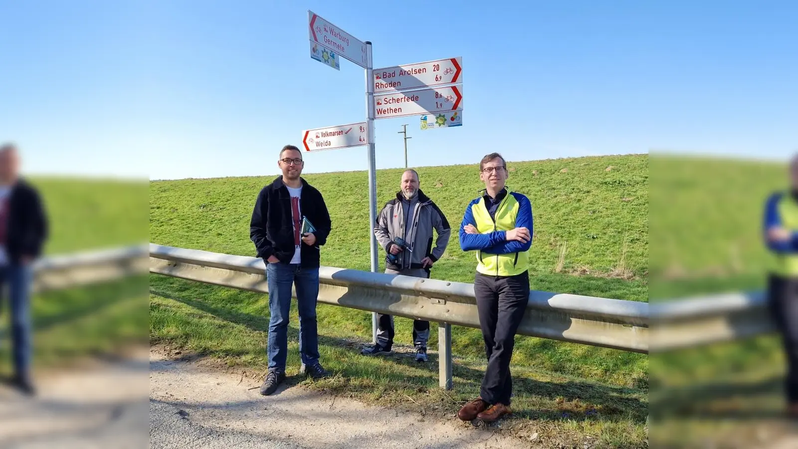 Tobias Scherf, Bürgermeister der Hansestadt Warburg, Kai Huckfeldt, Werbe- &amp; Verkehrstechniker OKA, und Jan Kolditz, Mobilitätsmanager, begutachten einen fertigen Wegweiser am Diemelradweg bei Germete. (Foto: Stadt Warburg)
