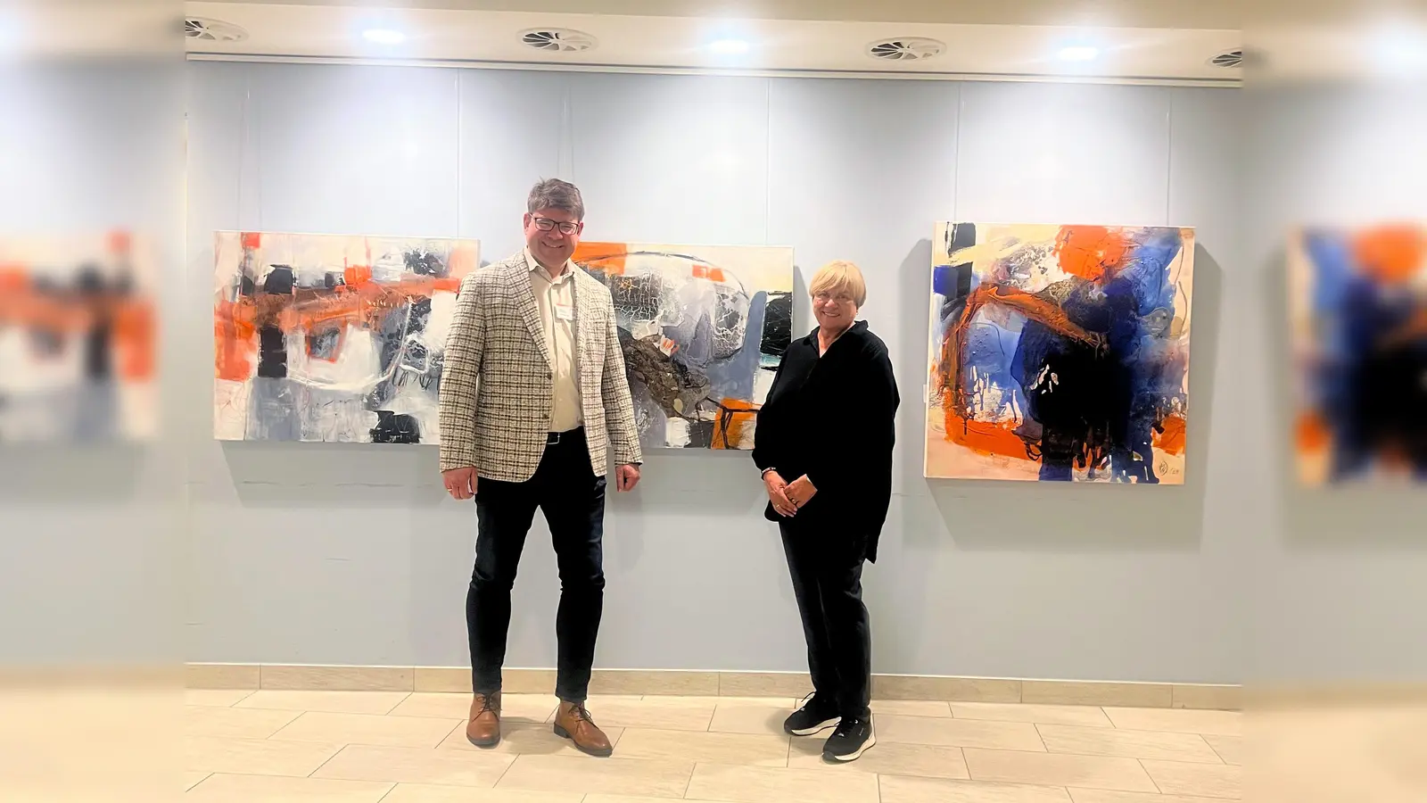 Standortleiter Marko Ellerhoff freut sich gemeinsam mit Martina Weskamp Dittmann über das kunstvolle Foyer, das noch bis Ende Juni bestaunt werden kann. (Foto: KHWE)