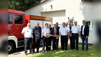 Bei der symbolischen Schlüsselübergabe (v.l.): Jürgen Rabbe (Leiter Feuerwehr Warburg), Michael Blome (Ratsmitglied aus Menne), Christian Moors (Leiter Löschgruppe Menne), Ludwig Amrehn, Bürgermeister Tobias Scherf, Kevin Wischer, Dominik Quere (stellv. Leiter Löschgruppe Menne), Florian Henschen, Ulrich Klare (stellv. Leitung Fachbereich Bauen und Stadtentwicklung), Reiner Vössing (stellv. Leiter der Feuerwehr und Architekt) und der erste Beigeordnete Andreas Niggemeyer. (Foto: Stadt Warburg)