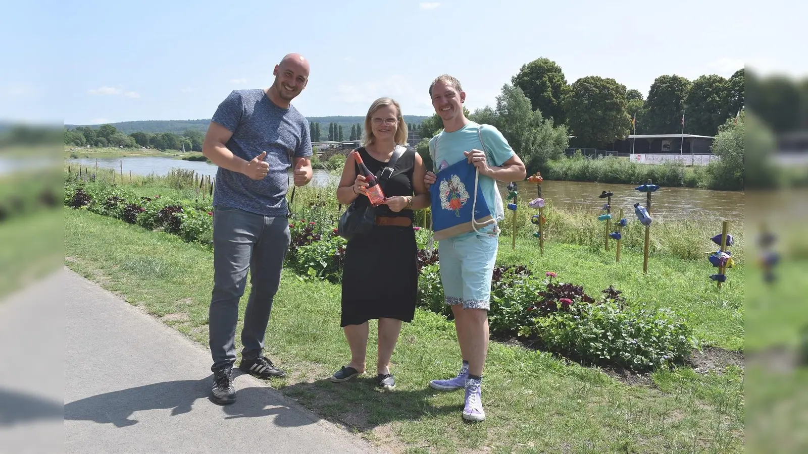 Eva Bobbert (Mitte) aus Münster ist die 222.222. Besucherin der Landesgartenschau Höxter. Geschäftsführer Jan Sommer (links) hat sie und Ralf Schneider (rechts) deswegen mit einem Wochenende in Höxter überrascht. Bobbert und Schneider sind Pflanzenliebhaber und freuen sich auf einen erneuten Besuch in Höxter. (Foto: LGS Höxter 2023)