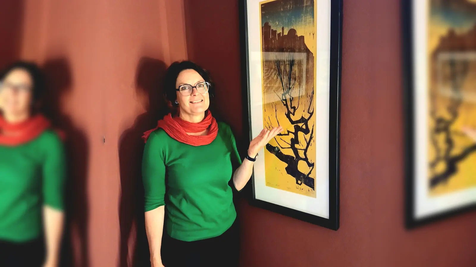 Kuratorin Elisabeth Brügger präsentiert einen mehrfarbigen Holzschnitt von Jacob Pins. (Foto: Forum Jacob Pins)