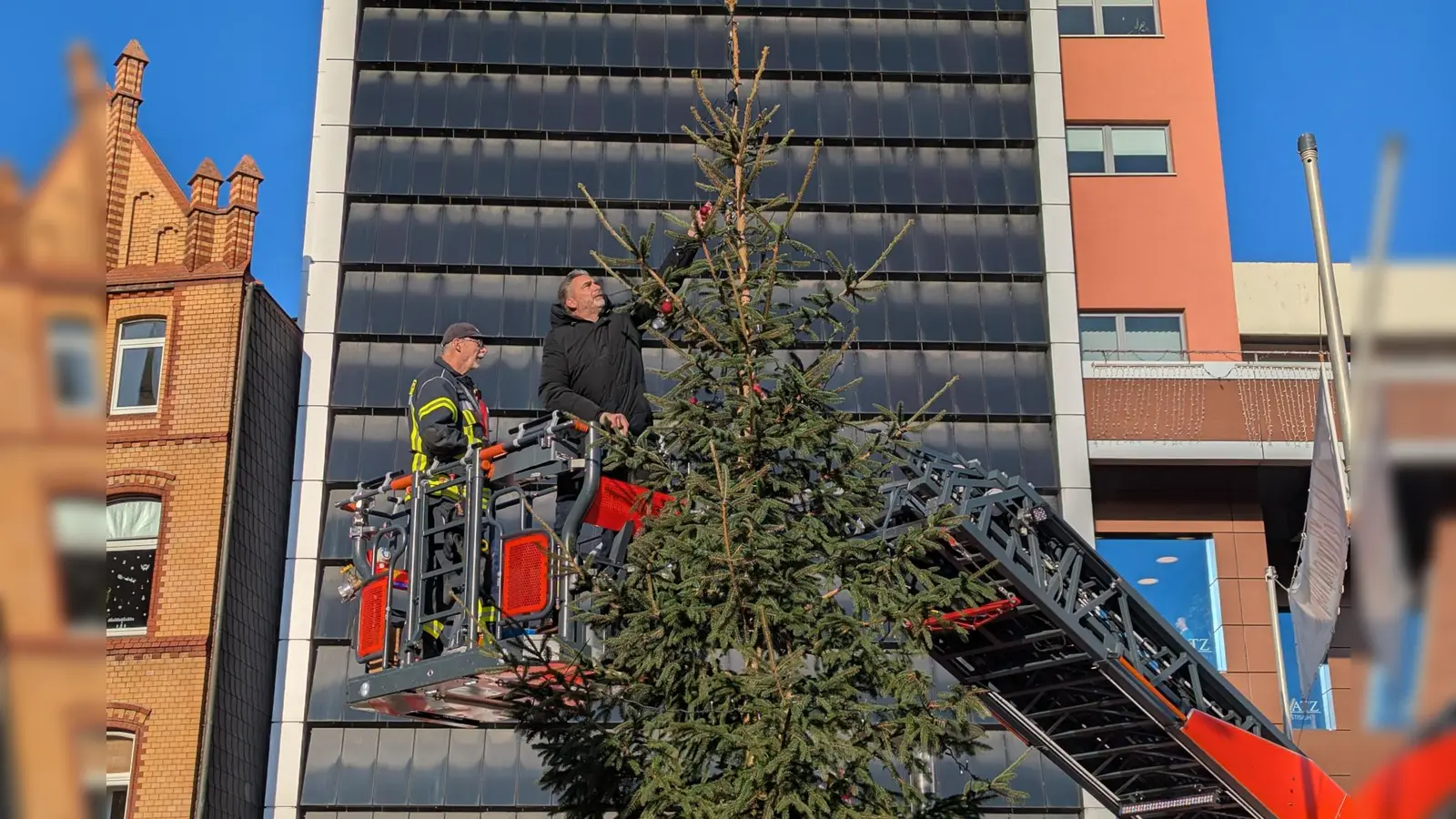 Bürgermeister Christian Belke schmückt den „Little Ugly Christmas Tree“ bis zur Spitze. (Foto: Stadtmarketing Holzminden GmbH)