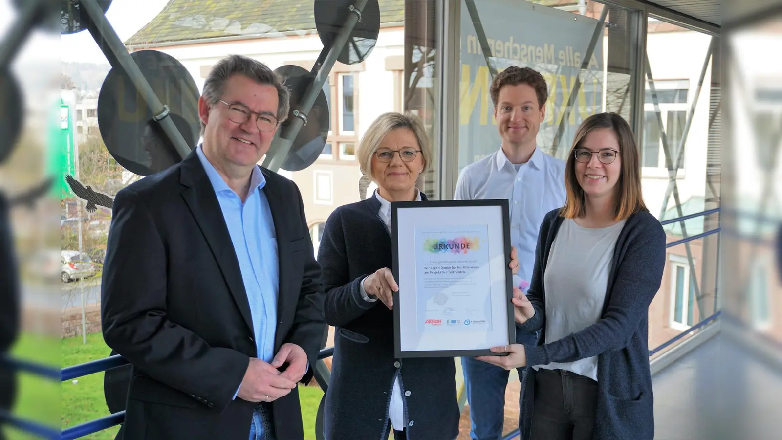 Präsentation der Dankes-Urkunde bei der symbolischen Übergabe der Projektergebnisse in der Kreisverwaltung Höxter (v.l.): Christian Rodemeyer (Kreisverwaltung Höxter, Leitung Abteilung Kinder, Jugend und Familie), Heike Lubs (Projektleitung), Jerome Major (Geschäftsführung Lebenshilfe Brakel) und Deborah Scherf (Kreisverwaltung Höxter, Abteilung Jugendförderung / Jugendschutz). (Foto: privat)