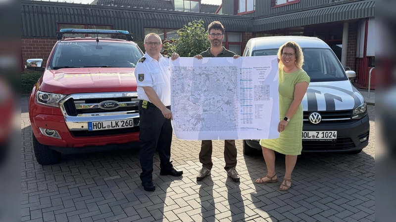 Übergabe der Waldbrandeinsatzkarten vom Kreiswaldbrandbeauftragten Christian Ridder an Kreisbrandmeister Michael Eisenbeis und die Erste Kreisrätin Sarah Humburg. (Foto: Kreisfeuerwehr Holzminden - Hendrik Meier)