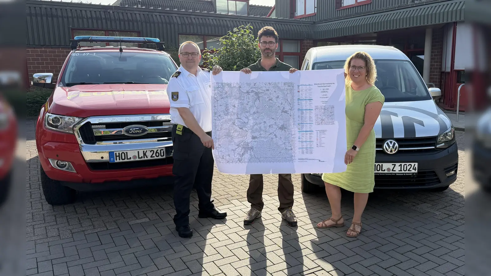 Übergabe der Waldbrandeinsatzkarten vom Kreiswaldbrandbeauftragten Christian Ridder an Kreisbrandmeister Michael Eisenbeis und die Erste Kreisrätin Sarah Humburg. (Foto: Kreisfeuerwehr Holzminden - Hendrik Meier)