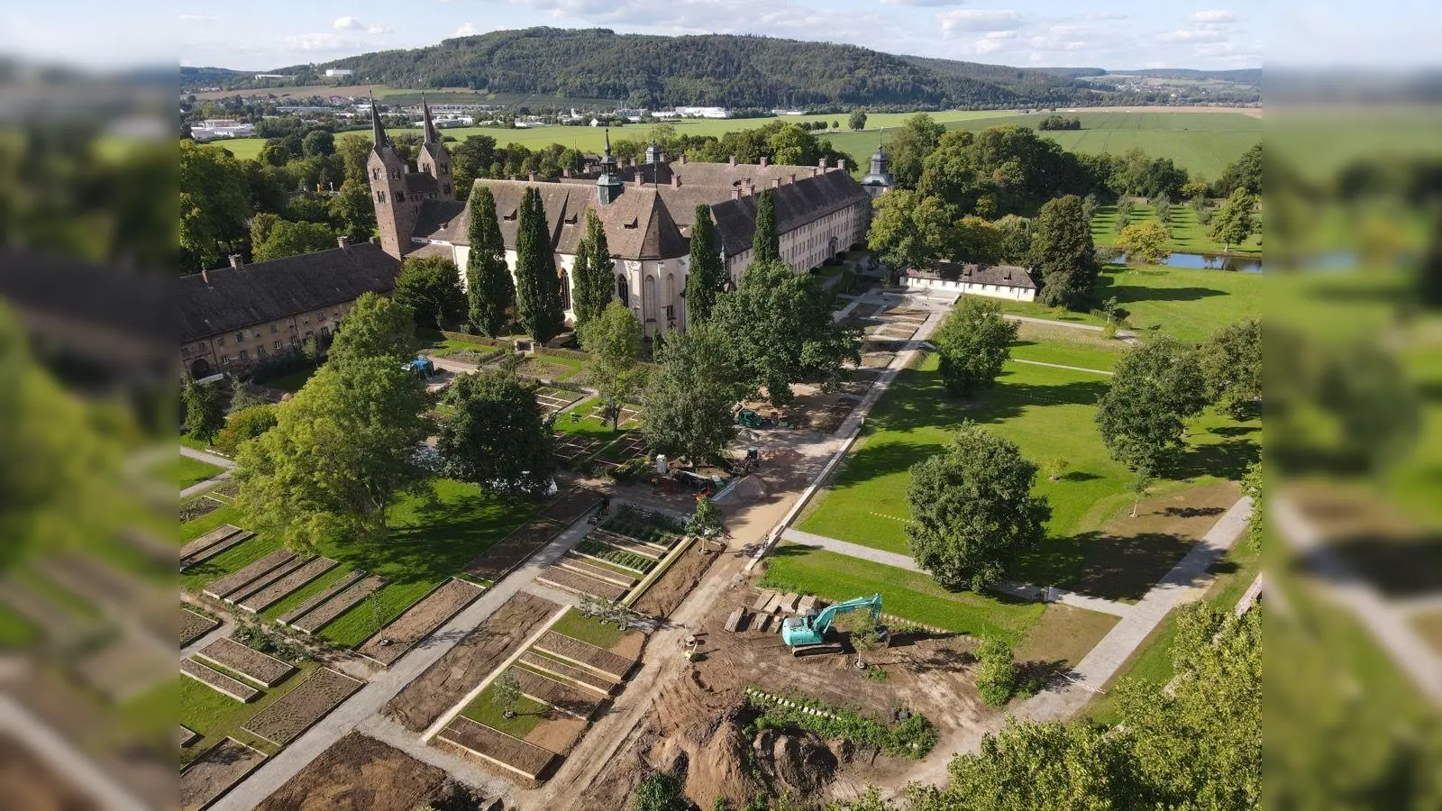 Zu Füßen des 1.200-jährigen Corveyer Westwerks entsteht im Schutz hoher Klostermauern der sogenannte Remtergarten, der mit botanischen Kostbarkeiten, heilsamen Kräutern, alten Gemüsesorten und einer Outdoorküche punkten will. Diese Drohnenaufnahme entstand bei den Bauarbeiten im Herbst. (Foto: LGS 2023 Höxter/Maike Koegel)